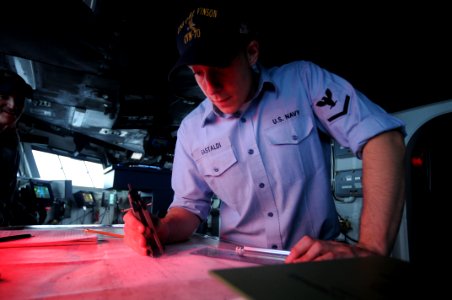 US Navy 090911-N-9132C-017 Quartermaster 3rd Class Daniel Gastaldi, assigned to the Nimitz class aircraft carrier USS Carl Vinson (CVN 70), plots a chart at the navigation table on the bridge of the aircraft carrier USS Ronald