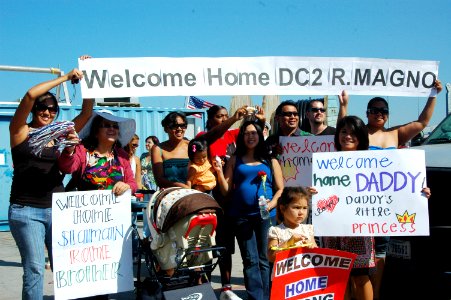 US Navy 090909-N-0209M-003 Family members and friends wave signs and cheer as the mine countermeasures ship USS Sentry (MCM 3) arrives at its new homeport at Naval Base San Diego
