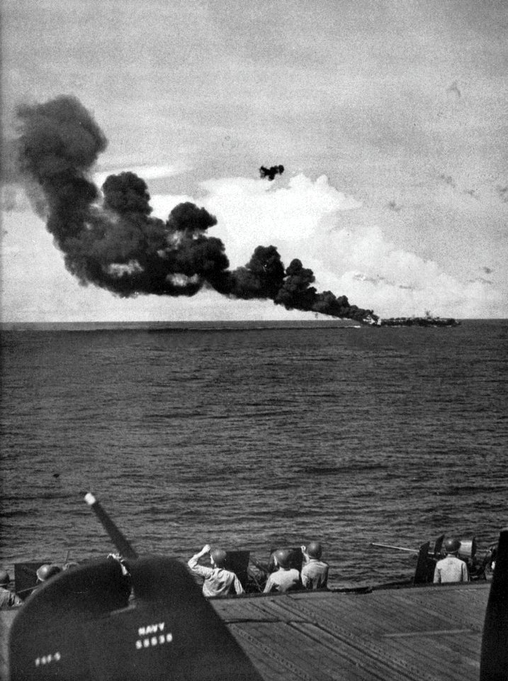 USS Belleau Wood (CVL-24) burning after she was hit by a Kamikaze off Luzon, Philippines, 30 October 1944