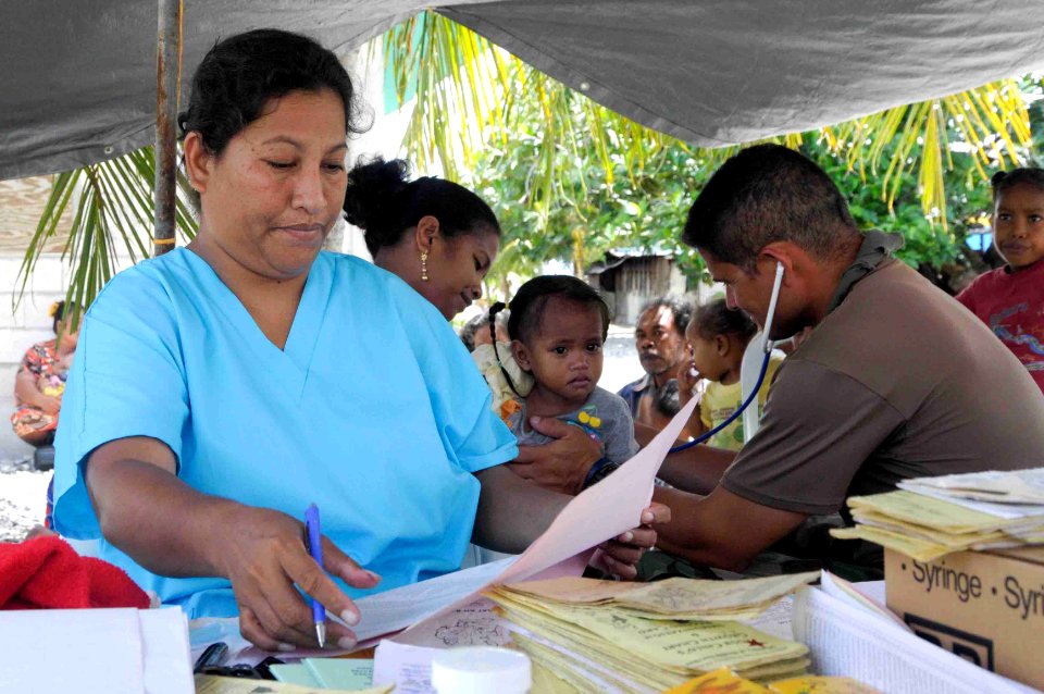 US Navy 090909-N-9689V-003 Herkko Neamon, left, a nurse from Ailinglaplap, helps Cmdr. Scott Cota treat patients during a Pacific Partnership 2009 medical civic action project