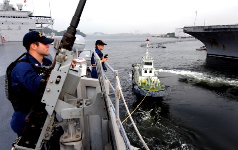 US Navy 090908-N-7280V-181 Gunner's Mate 3rd Class James Wilkerson mans the .50-caliber machine gun and Ensign Natalie Ferbezar stands the forward range-finder watch as the amphibious command ship USS Blue Ridge (LCC 19)