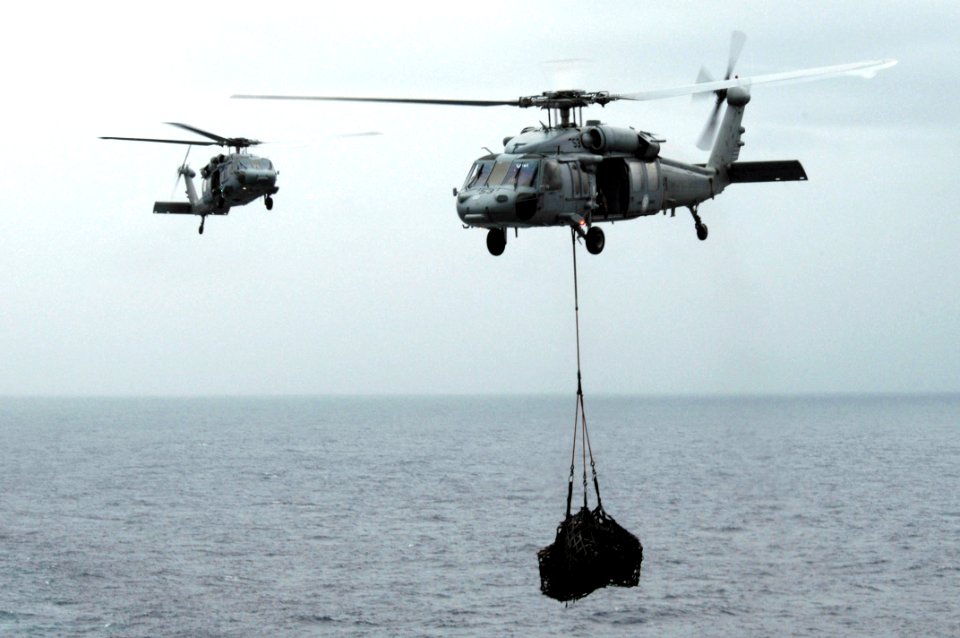 US Navy 090913-N-3038W-183 Two MH-60S Sea Hawk helicopters assigned to the Wild Cards of Helicopter Sea Combat Squadron (HSC) 23 fly supplies from the aircraft carrier USS Nimitz (CVN 68)