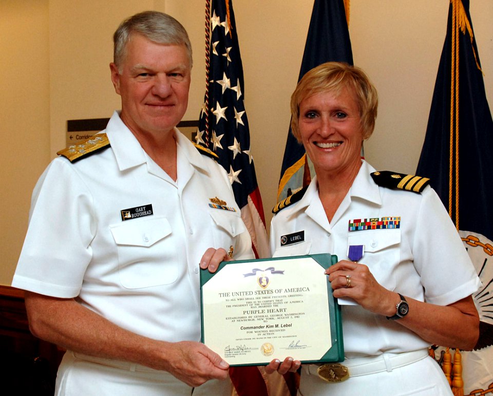US Navy 090911-N-8273J-207 Chief of Naval Operations (CNO) Adm. Gary Roughead presents the Purple Heart medal to Cmdr. Kim LeBel for wounds received in action during her individual augmentee assignment in Afghanistan