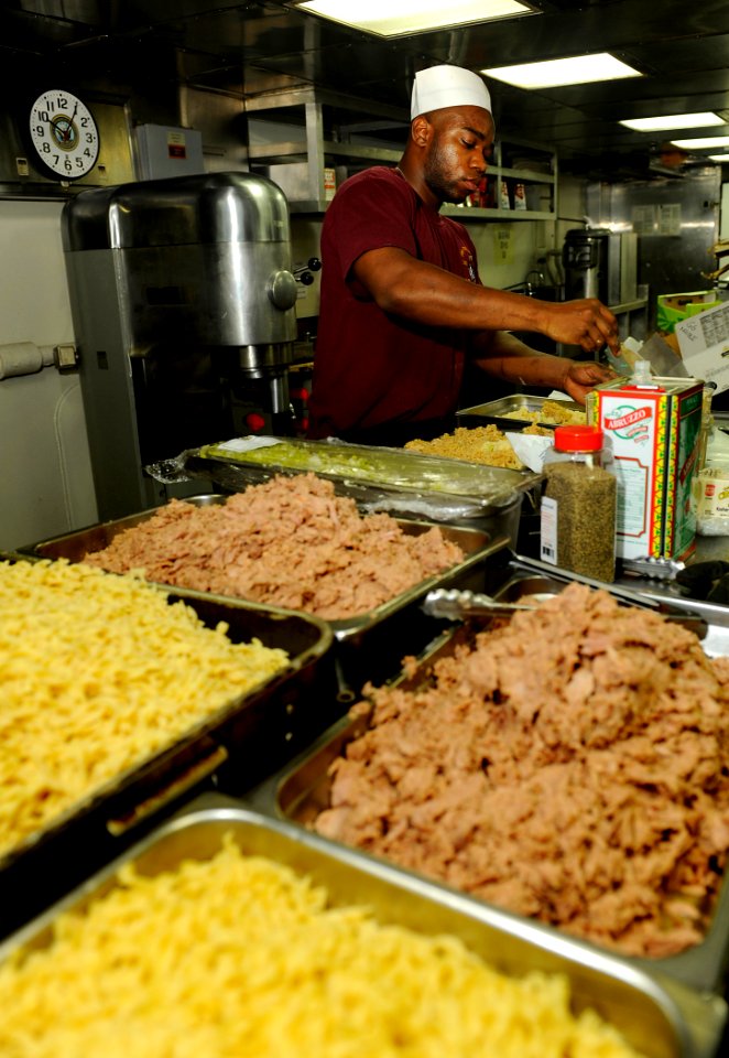 US Navy 090914-N-5345W-130 Culinary Specialist Seaman Gregory Lucas gathers ingredients to prepare lunch in the galley aboard the amphibious dock landing ship USS Fort McHenry (LSD 43)
