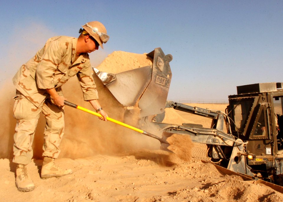 US Navy 090912-N-4440L-137 Construction Mechanic 3rd Class Shaun Boyce, assigned to Naval Mobile Construction Battalion (NMCB) 74, levels sand in HESCO container units