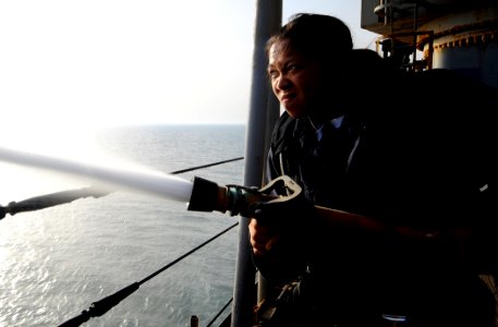 US Navy 090914-N-5345W-246 Fireman Priscilla Carbajal tightens her grip on the fire hose while participating in a hose-handling training exercise on the boat deck of the amphibious dock landing ship USS Fort McHenry (LSD 43)