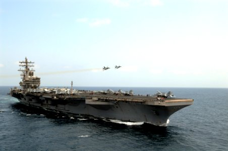 US Navy 090912-N-1635S-113 Two F-A-18E Super Hornets assigned to the Eagles of Strike Fighter Squadron (VFA) 115, fly over the flight deck of the aircraft carrier USS Ronald Reagan (CVN 76) after conducting an airborne change o
