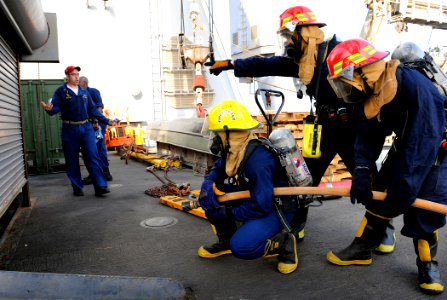 US Navy 090914-N-5345W-206 Chief Damage Controlman Donald Grothe, left, evaluates a fire team during a simulated fire on the boat deck of the amphibious dock landing ship USS Fort McHenry (LSD 43)