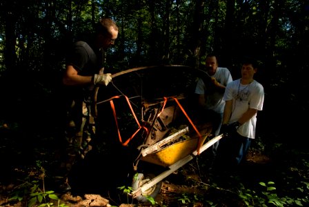 US Navy 090913-N-3541A-059 Aviation Maintenance Administrationman 3rd Class Shon Nutting, and area business owner Jonathan Buesch wheel the rusted front end metal from an abandoned vehicle in Illahee Forest Preserve in East Bre