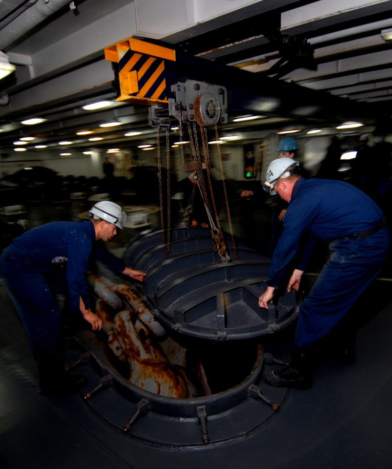 US Navy 090914-N-6538W-004 Sailors assigned to deck department, 1st Division remove the anchor chain cover above the starboard side haws pipe