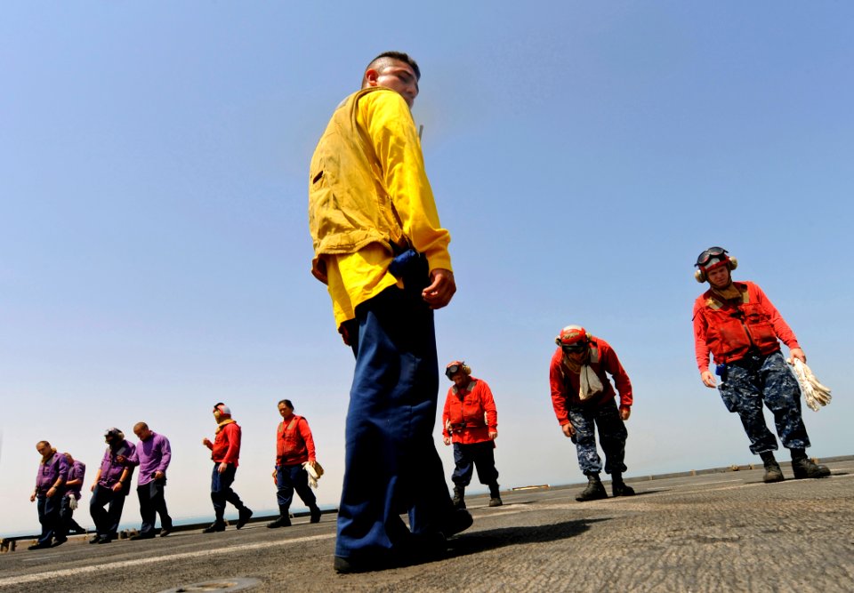 US Navy 090914-N-5345W-193 Boatswain's Mate 1st Class Israel Idrovo leads the flight deck team of the dock landing ship USS Fort McHenry (LSD 43) during a foreign object debris walkdown before scheduled flight operations