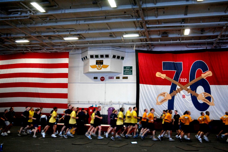 US Navy 090913-N-9818V-065 Sailors aboard the aircraft carrier USS Ronald Reagan (CVN 76) conduct morning physical training in the hangar bay of the ship