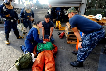 US Navy 090914-N-5345W-211 Hospital Corpsman 1st Class David Ancheta, right, asks Hospital Corpsman 2nd Class Ambar Vega what steps she'll take while responding to a simulated personnel casualty photo
