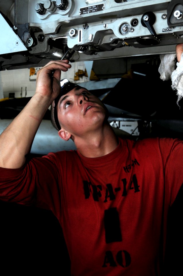 US Navy 090914-N-3038W-083 Aviation Ordnanceman Airman Seth Houston, assigned to the Tophatters of Strike Fighter Squadron (VFA) 14, inspects and cleans a BRU-32 bomb rack