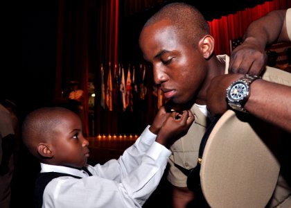 US Navy 090916-N-2013O-089 Chief Operations Specialist Temi Jones of the guided-missile destroyer USS Stethem (DDG 63), has his chief petty officer anchors pinned onto his collar by his son during the FY-10 CPO pinning ceremony