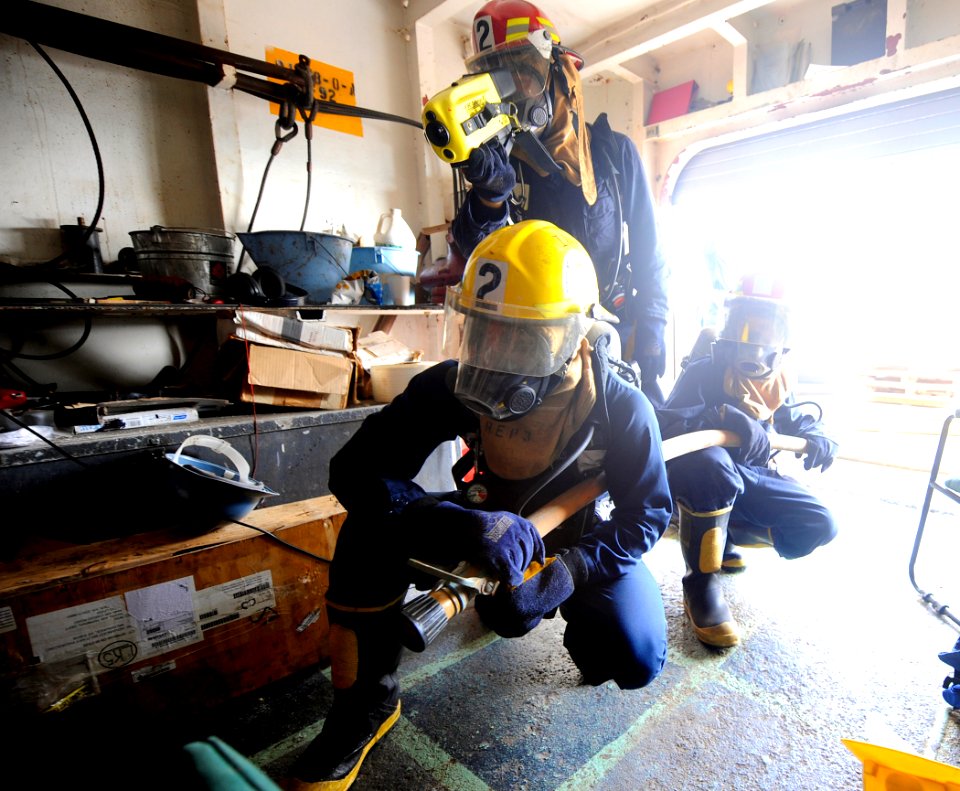 US Navy 090914-N-5345W-214 Fire team members use a Naval Firefighter's Thermal Imager to search for hot spots while responding to a simulated fire on the boat deck of the amphibious dock landing ship USS Fort McHenry (LSD 43)