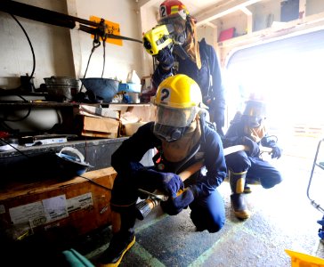 US Navy 090914-N-5345W-214 Fire team members use a Naval Firefighter's Thermal Imager to search for hot spots while responding to a simulated fire on the boat deck of the amphibious dock landing ship USS Fort McHenry (LSD 43)