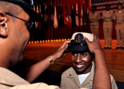 US Navy 090916-N-2013O-060 Chief Damage Controlman Shenia Nurse of Afloat Training Group Western Pacific, is presented her chief petty officer combination cover during the FY-10 CPO pinning ceremony at Commander Fleet Activitie