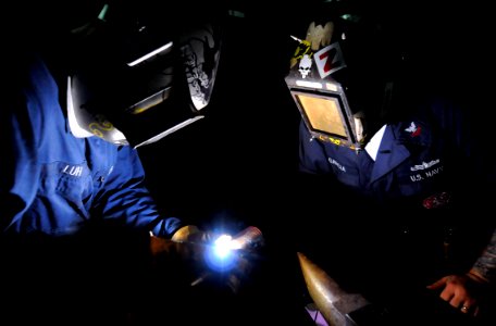 US Navy 090914-N-7280V-303 Hull Maintenance Technician 2nd Class Paris Luh and Hull Maintenance Technician 2nd Class Adrian Garcia weld on a tubing for a collection, holding and transfer line