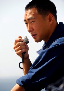 US Navy 090916-N-5345W-107 nsign Kenneth Lee communicates with the amphibious dock landing ship USS Fort McHenry pilot house while operating as the ship's conning officer during a connected replenishment at sea