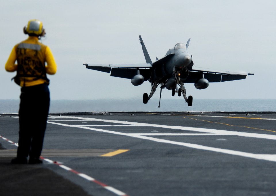 US Navy 090916-N-6538W-392 Aviation Boatswain's Mate (Handling) Airman Nathan Wiuff, from McKinney, Texas, observes an F-A-18C Hornet from the Rough Raiders of Strike Fighter Squadron (VFA) 125