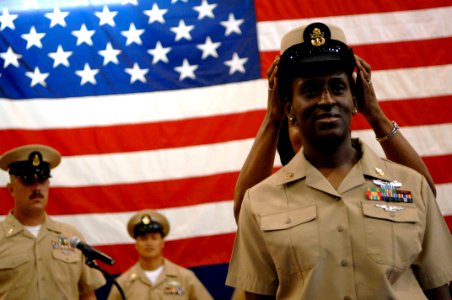 US Navy 090916-N-9818V-183 Chief Information Systems Technician Erica Barnett has chief anchors pinned on her uniform as a chief's combination cover is placed on her head at the Southwest Asia FY2010 Chief Petty Officers Pinnin