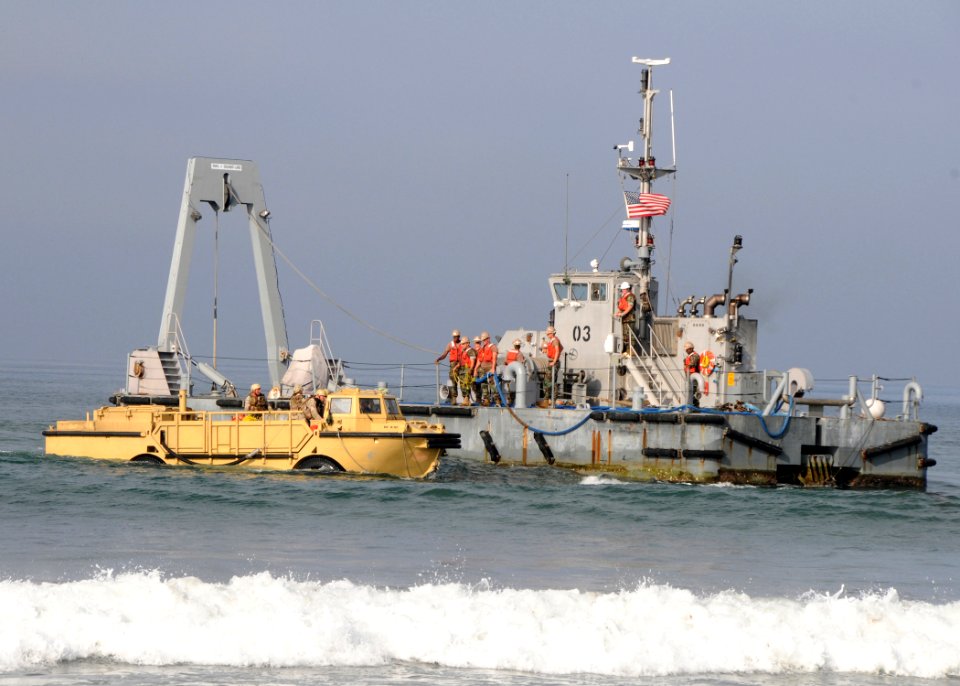 US Navy 090917-N-1424C-428 Seabees assigned to Amphibious Construction Battalion (ACB) 1 aboard Warping Tug 03 stand by to give a towing line to Sailors assigned to Beach Master Unit (BMU) 1 aboard the lighter amphibious resupp
