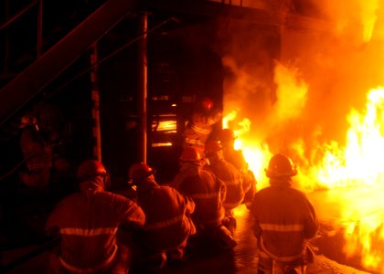 US Navy 090915-N-2147L-001 Sailors assigned to the Flying Squad of the dock landing ship Pre-Commissioning Unit (PCU) New York (LPD 21) practice night firefighting techniques photo