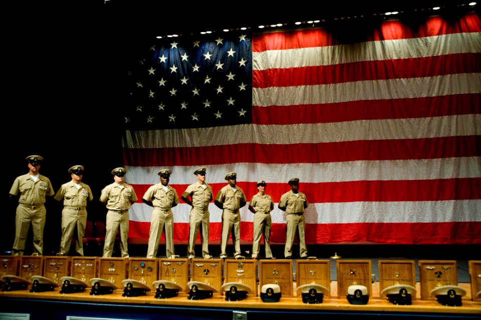 US Navy 090916-N-4776G-036 Newly pinned chief petty officers stand on stage while they wait for other chiefs selects to be pinned and join them during a chief pinning ceremony at the Naval Amphibious Base Little Creek theater