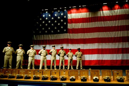 US Navy 090916-N-4776G-036 Newly pinned chief petty officers stand on stage while they wait for other chiefs selects to be pinned and join them during a chief pinning ceremony at the Naval Amphibious Base Little Creek theater photo