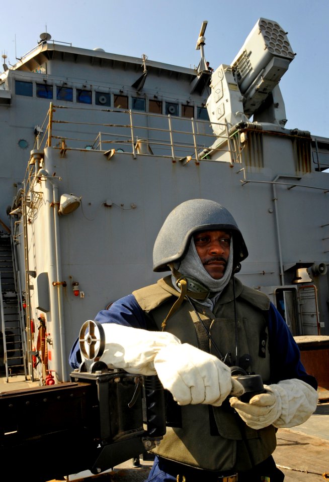 US Navy 090917-N-5345W-006 Culinary Specialist 2nd Class Alan Marshall looks out over the bow while standing .50-caliber machine gun watch on the foc'sle during a general quarters drill