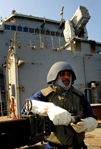 US Navy 090917-N-5345W-006 Culinary Specialist 2nd Class Alan Marshall looks out over the bow while standing .50-caliber machine gun watch on the foc'sle during a general quarters drill