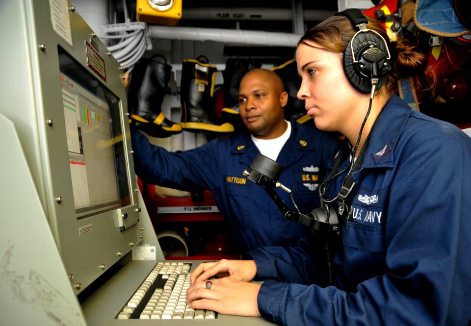 US Navy 090918-N-6003P-002 Chief Machinist's Mate Lamont D. Mattison trains a Sailor on the damage control locker computer during a general quarters drill aboard the aircraft carrier USS Harry S. Truman (CVN 75)