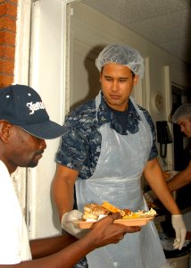 US Navy 090918-N-8560K-071 Machinery Repairman 3rd Class Jared T. Shaver assigned to the aircraft carrier USS George H.W. Bush (CVN 77) serves a tray of food during a lunchtime meal at St. Vincent De Paul Catholic Church