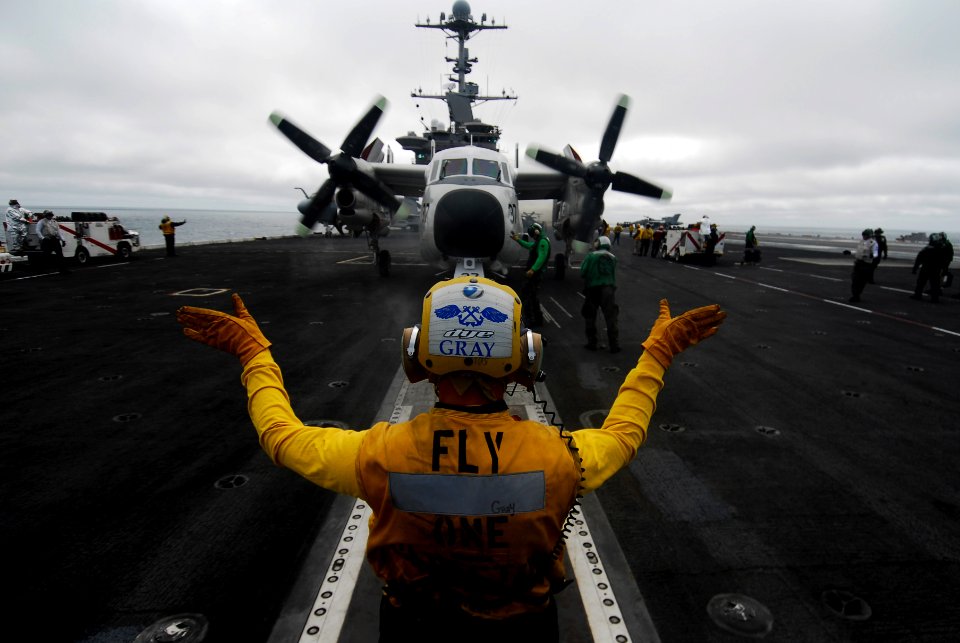 US Navy 090919-N-6538W-232 Aviation Boatswain's Mate (Handling) 3rd Class Scott Gray, from Salt Lake City, Utah, guides a C-2A Greyhound