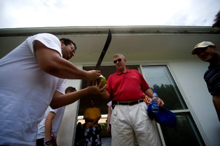 US Navy 090921-N-4154B-049 Rear Adm. (lower half) Scott E. Sanders, commander of Combined Task Force (CTF) 151, receives a coconut from one of the workers at a local rehabilitation clinic photo