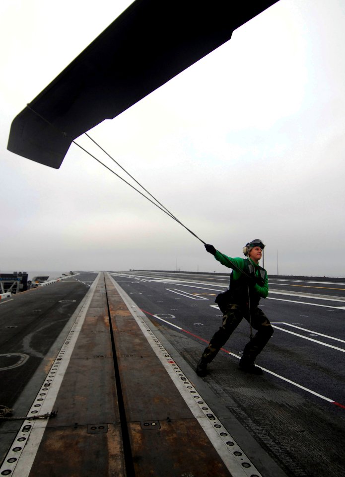 US Navy 090918-N-6538W-010 viation Structural Mechanic 2nd Class Evan Young, from Sonora, Calif., stabilizes a rotor blade on an MH-60S Sea Hawk