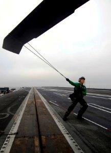 US Navy 090918-N-6538W-010 viation Structural Mechanic 2nd Class Evan Young, from Sonora, Calif., stabilizes a rotor blade on an MH-60S Sea Hawk