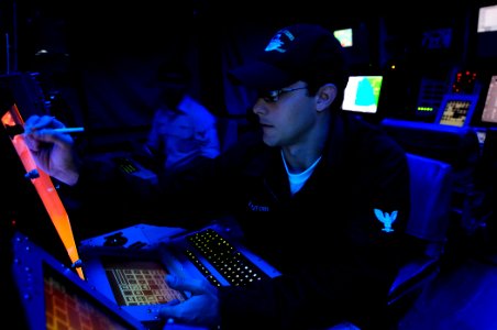US Navy 090922-N-9928E-093 Operations Specialist 2nd Class Dereck Pengitore, from Patterson, N.J., gives air intercept training to Operations Specialist 2nd Class Keegan Wigger, from Olympia, Wash., in the Combat Direction Cent