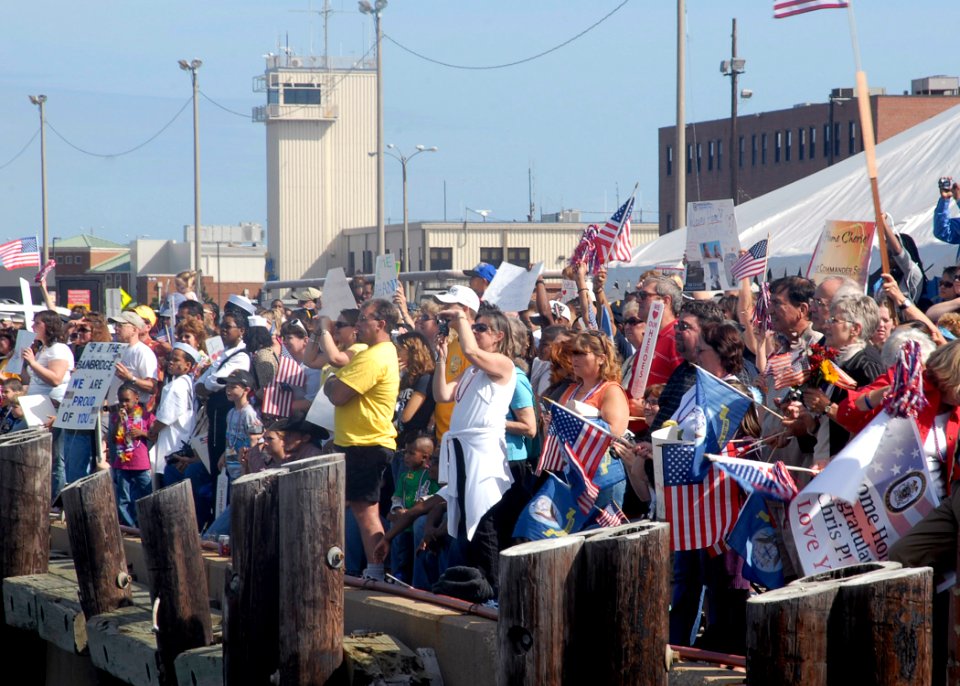US Navy 090921-N-2456S-026 Friends and family members cheer as Sailors assigned to the guided-missile destroyer USS Bainbridge (DDG 96) return to their homeport at Naval Station Norfolk, Va