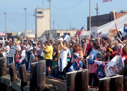 US Navy 090921-N-2456S-026 Friends and family members cheer as Sailors assigned to the guided-missile destroyer USS Bainbridge (DDG 96) return to their homeport at Naval Station Norfolk, Va