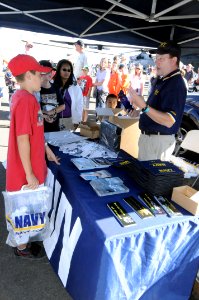 US Navy 090920-N-6220J-001 Andy Doty, a retired Navy chief who now works as a civilian for the Navy Recruiting District, Portland, Ore., speaks with youths at a Navy exhibit photo