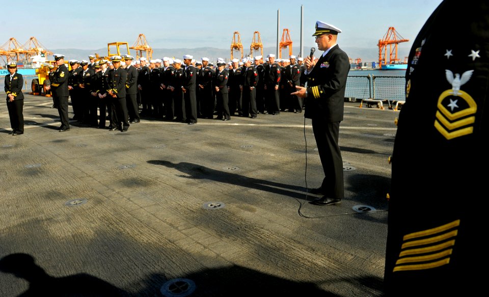 US Navy 090925-N-5345W-034 Executive Officer Cmdr. Brian Goldschmidt addresses the crew following an all hands uniform inspection aboard the amphibious dock landing ship USS Fort McHenry (LSD 43) during a port visit to Salalah