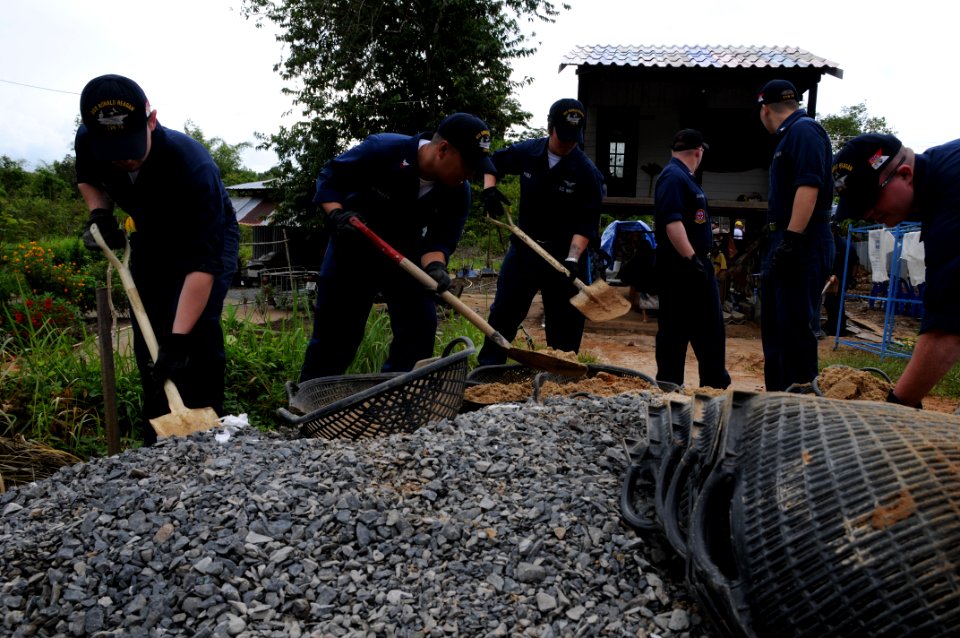 US Navy 090924-N-4995K-025 Sailors assigned to the aircraft carrier USS Ronald Reagan (CVN 76) shovel rocks and sand during the construction of a Habitat for Humanity house in Thailand