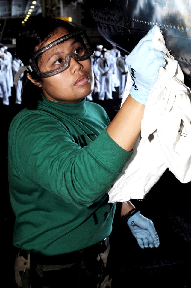 US Navy 090921-N-3038W-047 Aviation Airman Catherine Ramos, assigned to the Indians of Helicopter Anti-Submarine Squadron (HS) 6, cleans the tail section of an SH-60F Sea Hawk helicopter in the hangar bay aboard the aircraft ca