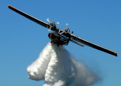 US Navy 090925-N-9860Y-006 A PBY-6A Catalina drops a load of water from its bomb-bay doors over Crescent Harbor
