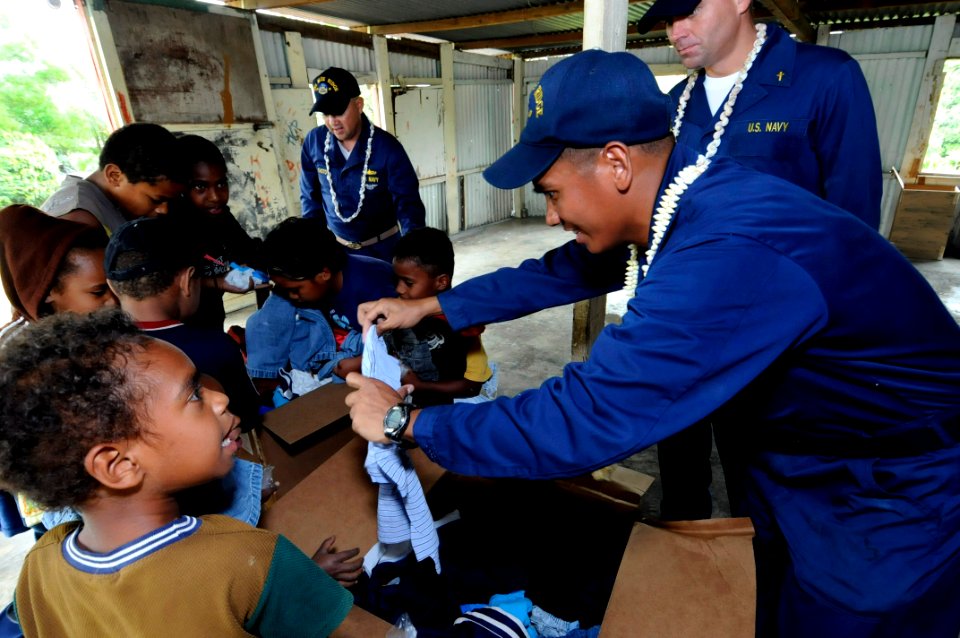 US Navy 090925-N-7478G-354 Storekeeper 1st Class Antonio Hombrebueno, Chief Warrant Officer 3 Carlos Choto, and Chaplain Steven Benefield assigned to the amphibious command ship USS Blue Ridge (LCC 19) hand out clothing to chil