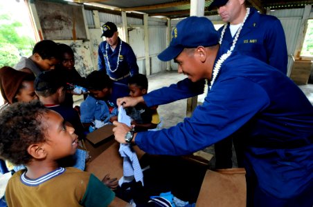 US Navy 090925-N-7478G-354 Storekeeper 1st Class Antonio Hombrebueno, Chief Warrant Officer 3 Carlos Choto, and Chaplain Steven Benefield assigned to the amphibious command ship USS Blue Ridge (LCC 19) hand out clothing to chil