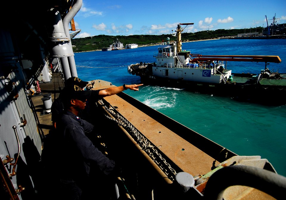 US Navy 090928-N-0807W-048 Tug boats guide the amphibious dock landing ship USS Harpers Ferry (LSD 49) from White Beach Naval Facility, Okinawa, Japan
