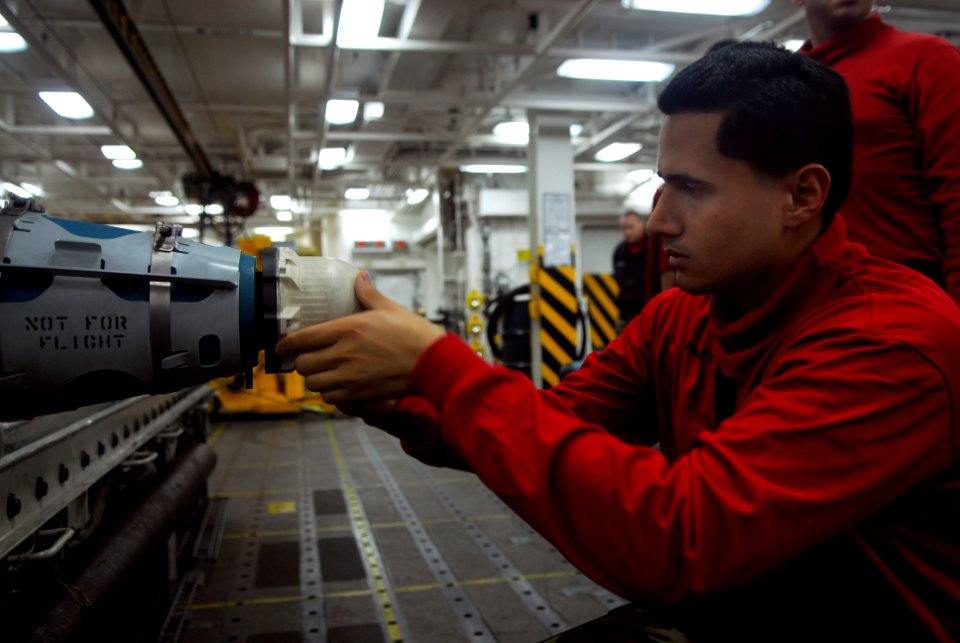 US Navy 090922-N-2475A-067 Aviation Ordnanceman Airman Antonio Sanchez, from New York City, installs a DSU-33 proximity sensor into an inert training bomb aboard the aircraft carrier USS John C. Stennis (CVN 74)